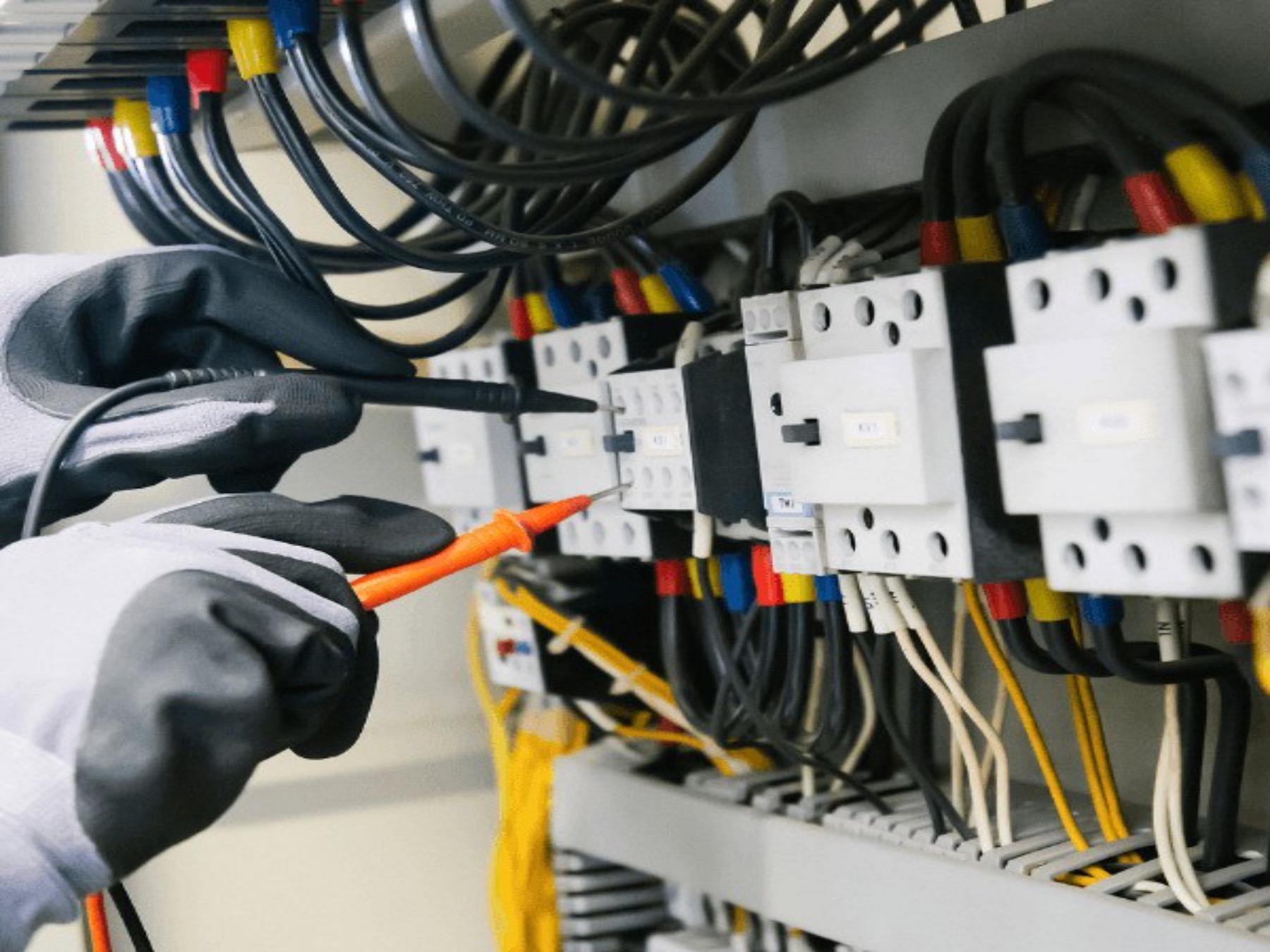 An electrician testing a modern electrical panel