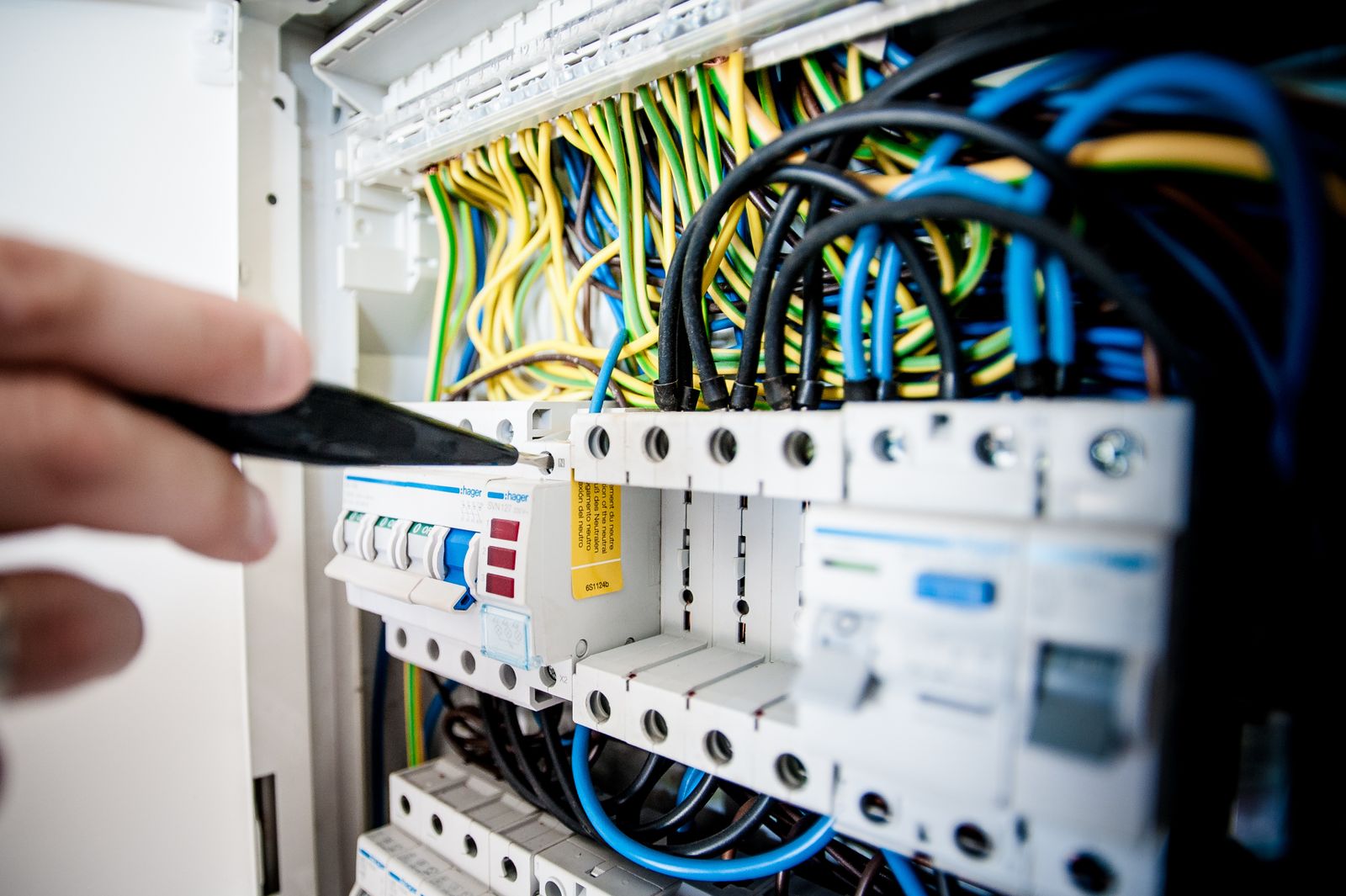 Hands completing careful work on an open switchboard