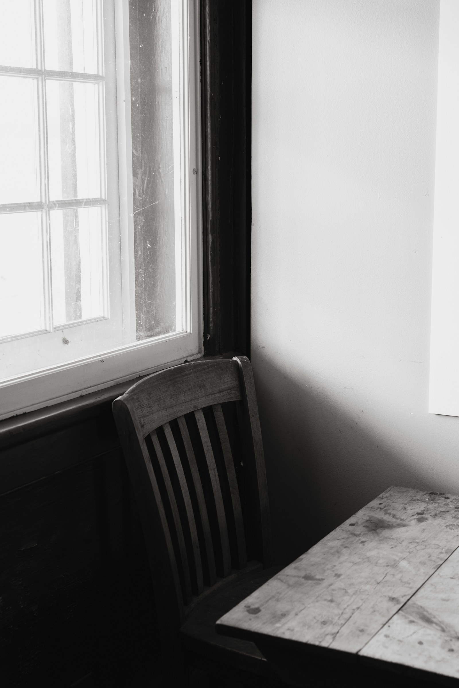 An empty chair beside a softly lit window